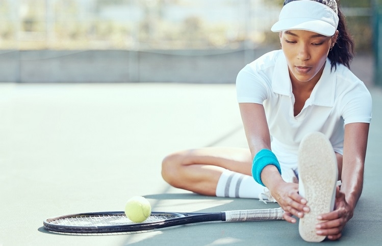 Female player sitting doing warm-up exercise - sports commentary